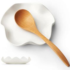 a wooden spoon sitting on top of a white plate next to an egg shaped bowl