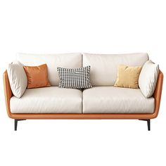 a white couch with two pillows on it's back and an orange pillow in the middle