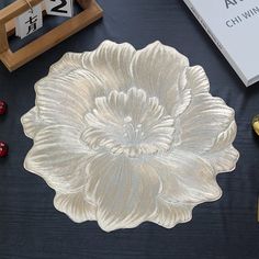 a white flower is sitting on a table next to some other decorations and books,