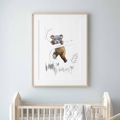 a baby's room with a teddy bear hanging on the wall and a crib