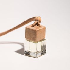 a small square glass bottle with a wooden stopper