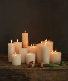 a group of lit candles sitting on top of a wooden table