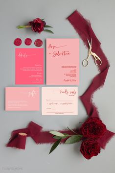 the wedding stationery is laid out on top of red ribbon and flowers with scissors