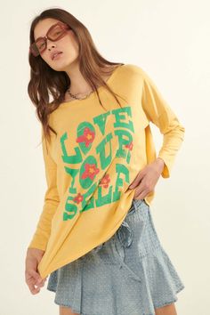 Mineral washed graphic t-shirt. Vintage-style "Love Yourself " text print with retro flower graphics. Round neckline. Long sleeves. Drop shoulder. Loose, oversized fit. 100% Cotton. Imported top designed and printed in LA. Model wears size S. Retro Long Sleeve T-shirt For Spring, Vintage Text Print T-shirt For Spring, Hippie Soft-washed Relaxed Fit Tops, Hippie Style Soft-washed Relaxed Fit Top, Hippie Printed Crew Neck Top, Hippie Crew Neck Top With Relaxed Fit, Hippie Crew Neck Relaxed Fit Top, Hippie Style Crew Neck Top With Relaxed Fit, Hippie Relaxed Fit Crew Neck Top