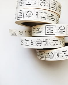 four rolls of white tape with numbers on them are stacked up in the shape of letters