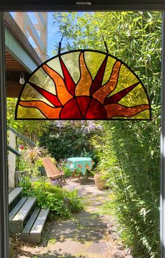 a stained glass sunburst hanging from the side of a window