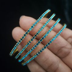 "* Handcrafted Gold Plated 4 Bangle Set. Sold as a set. * Bangles with high quality blue stones. * High Quality 22K Gold Plated. Bangles Sizes : 2.4 ( 2.20\" diameter of the inner circle) ; 2.6 ( 2.40\" diameter of the inner circle); 2.8 (2.50\" diameter of the inner circle) The gorgeous gold-plated bangles set best exemplifies the careful craftsmanship done on it -- specially picked for you by Nemali Jewelry. It has a special tone of elegance attached to it. The intricate handmade design of the Blue Bangle Bracelet For Wedding, Blue Hand Set Bangle For Wedding, Blue Bangle Bracelets For Wedding, Blue Hand-set Bangle For Wedding, Adjustable Blue Stackable Bangle, Blue Festive Bracelet Jewelry, Festive Blue Bracelet Jewelry, Festive Blue Round Bangle, Festive Blue Bracelet