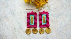 These woven miyuki earrings combine the striking colors of pink, turquoise and gold to create a truly striking piece of statement jewelry. Ideal for accenting outfits on the warm color spectrum, this piece of wearable art will become your favorite bohemian pair of earrings. The purchase of this listing is for one pair of earrings with the following specifications: Length: 1 1/4 inches Colors: Pink, turquoise, gold Each of these micro macramé earrings is expertly handcrafted by combining lightwei Micro Macrame Earrings, Miyuki Earrings, Woven Earrings, Beaded Necklace Patterns, Turquoise And Gold, Buy Earrings, Necklace Patterns, Macrame Earrings, Micro Macramé