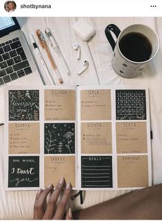 a person's hand on top of a notebook next to a cup of coffee