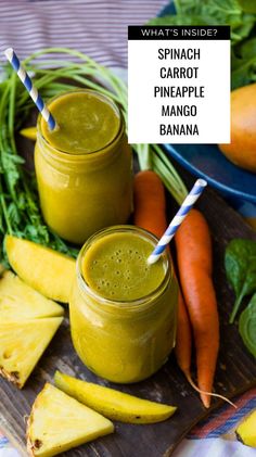 spinach carrot pineapple mango banana smoothie on a cutting board with fresh fruit and vegetables in the background