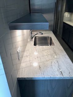 a kitchen counter top with a sink and faucet in the middle of it