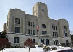 an old building with a flag on the front and snow on the ground around it