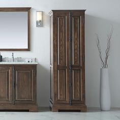 a bathroom with two wooden cabinets and a mirror on the wall next to it,