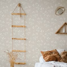 a white bed sitting next to a wall with a ladder hanging from it's side