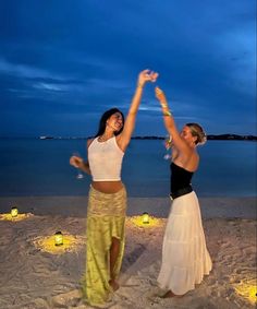 two women dancing on the beach at night