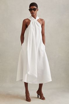 Find REISS Cosette Linen Blend Drape Midi Dress on Editorialist. The Cosette midi dress is made from a linen blend for natural flared movement. The halter neckline is ruched at the front and features a drape element which falls just above the hem. Linen blend. Ruche halter neckline. Drape element. Side pockets. Zip-closure to reverse. Midi length Halter Dresses Summer, Resort Chic Attire, Summer Dresses Linen, Linnen Dress, Summer Resort Outfits, Cream Midi Dress, White Linen Dress, Circular Art, Draped Midi Dresses