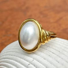 New, but old pieces, never worn, recently acquired from a premier jeweler located in Minneapolis, MN for many years- a rare opportunity! 18KT yellow Ggld genuine, bezel-set, white, oval, mabe pearl ring. Size 6.75 Sizable by us for a fee or your local jeweler Weight: 10.3 grams Band width: 3mm in back Pearl measures: 15mm x 11mm oval mabe pearl Stamped 18k By Honora Timeless Oval Rings With High Luster, Oval Yellow Gold Pearl Ring With High Luster, Oval Pearl Ring In Yellow Gold With High Luster, Elegant White Domed Jewelry, Yellow Gold Oval Pearl Ring With Polished Finish, Heirloom High Luster Oval Pearl Ring, Classic Cabochon Pearl Ring For Formal Occasions, Classic Oval Ring With High Luster, Gold Oval Cabochon Pearl Ring