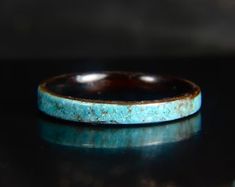 a blue ring sitting on top of a black table next to a white and brown object