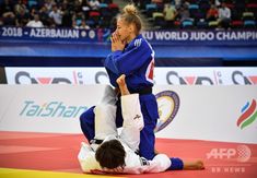 two women in blue and white uniforms are wrestling