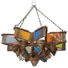 a chandelier hanging from a chain with multiple colored stained glass panels on it