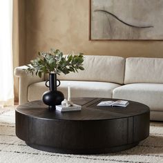 a living room with a couch, coffee table and vase