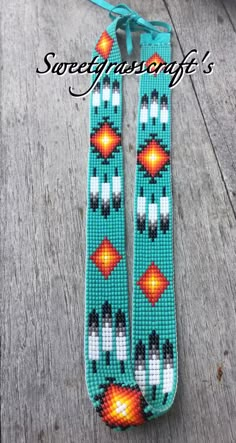 two beaded bracelets with orange and black beads on a wooden table next to a string