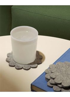 a glass of milk sitting on top of a table next to a stack of coins