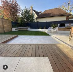 a backyard with wooden decking and grass