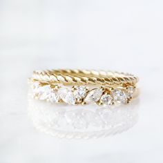 three gold wedding bands with diamonds on them