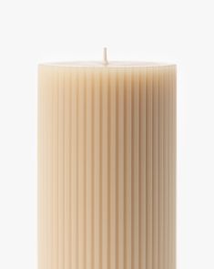 a candle that is on top of a white surface with the light reflecting off of it