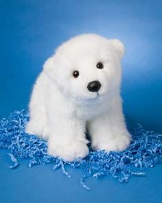 a white stuffed polar bear sitting on blue fabric