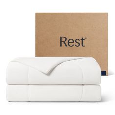 the rest bedding set in white is next to a cardboard box that says rest