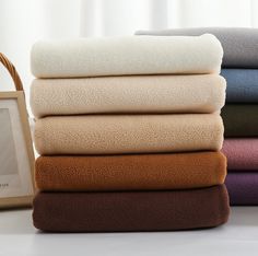 a stack of folded towels next to a basket