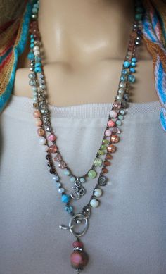 a mannequin wearing a multi - stranded necklace with beads and charms on it