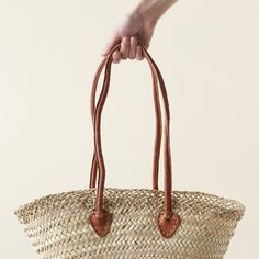 Elevate your everyday errands with this handmade Market Tote. Crafted from palm leaves and sturdy leather straps in Morocco, this versatile bag is perfect for shopping trips, weekend outings, or as a stylish messenger bag. With plenty of space and a customizable design, stay eco-friendly and chic with this reusable tote. Dimensions: 17" x 10" x 13" (leather strap: 10"H) Eco-friendly Satchel Beach Bag With Adjustable Strap, Ethically Sourced Natural Shoulder Bag For Vacation, Natural Beach Bag With Adjustable Strap, Natural Beach Bag With Adjustable Strap For Daily Use, Ethically Sourced Natural Bags For Vacation, Everyday Beach Bag With Adjustable Strap And Long Handle, Bohemian Palm Leaf Shoulder Bag For Everyday Use, Leather Handle Basket Shoulder Bag For Travel, Everyday Palm Leaf Basket Beach Bag