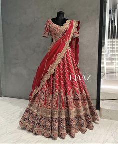 a red and gold lehenga is displayed on a mannequin headdress