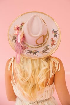 Unleash some playful style with the HORSESHOE PINK RANCHER HAT! This one-of-a-kind hat features a pink color palette with bold gold accents and a cream ribbon band. A racing horses design, gold horse bit patch, and pink floral design add a unique touch, perfect for an unforgettable Derby look. Giddy up! This hat is ONE Custom Spring Rodeo Hats, Bohemian Pink Hat For Rodeo, Multicolor Spring Rodeo Hat, Cowboy Hat With Flowers, Derby Dresses And Hats Outfit, Painted Hats For Women, Spring Rodeo Trucker Hat, Custom Cowgirl Hats, 70s Cowgirl