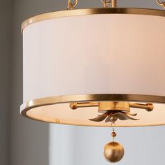 a chandelier hanging from the ceiling with a white shade on it's side