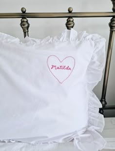 a white pillow with a heart embroidered on it