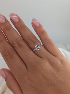 a woman's hand with a diamond ring on it