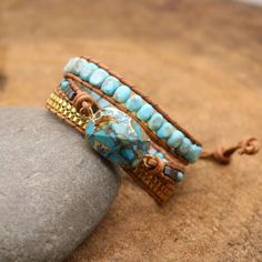 two beaded bracelets sitting on top of a rock