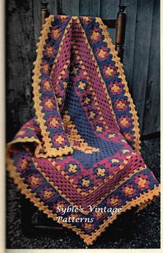 a crocheted blanket sitting on top of a wooden chair