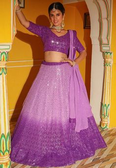 Readymade Faux Georgette Lehenga in Shaded Purple.This attire with Cotton and Shantoon Lining is Enhanced with Fancy Dangles, Resham and Sequins Work. Available with a Faux Georgette Purple Choli Crafted in Sweetheart Neck and Half Sleeves and a Faux Georgette Dupatta in Light Purple. The Choli and Lehenga Lengths are 15 and 42 inches respectively. We sell all kinds of Lehenga and Chaniya Choli Casual Lehenga |Sangeet Lehenga Choli |Wedding Lehenga Choli |Haldi Lehenga Choli |Mehandi Lehenga Cho Shaded Chaniya Choli, Purple Sequined Fitted Choli, Fitted Purple Sequined Choli, Purple Sequined Lehenga For Navratri, Purple Sequined Dupatta For Navratri, Purple Sequined Traditional Wear For Diwali, Purple Sequined Sets For Navratri, Purple Sequins Sets For Navratri, Purple Bollywood Traditional Wear With Sequins