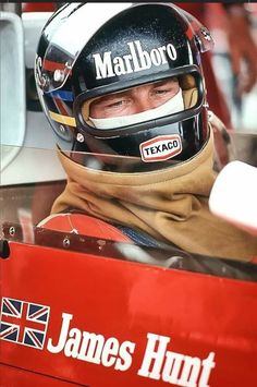 a man sitting in a race car wearing a helmet with the name james hunt on it