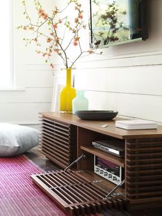 an entertainment center in the corner of a room with a pink rug on the floor