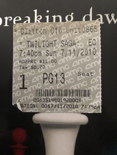 the ticket for breaking dawn is displayed in front of a black and white sign that says,