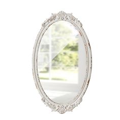 a white oval mirror sitting on top of a wall