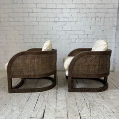 two chairs sitting next to each other in front of a white brick wall and floor