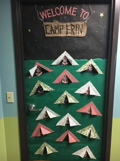 a door decorated with paper campers and the words welcome to campfire