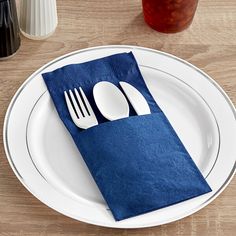 a white plate topped with a blue napkin and silverware